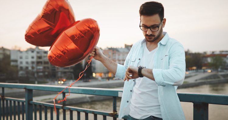 Man holding heart balloons